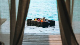 Floating brunch tray behind curtains at the Vakkaru Maldives