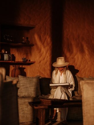 Hotel room design woman reading on couch at Zannier Hotels Omaanda by Laura and Nicolas Herbert @laurandnicolas