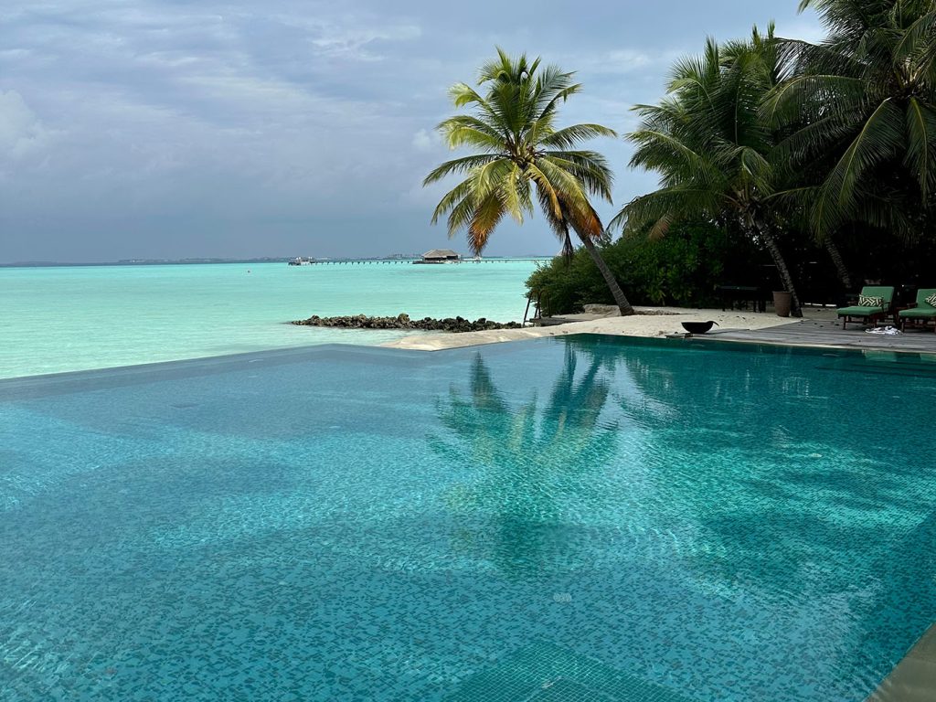 Taj Exotica Resort & Spa Maldives resort pool beside turquoise ocean by Roxana Cozma of Wanderlust Voyager