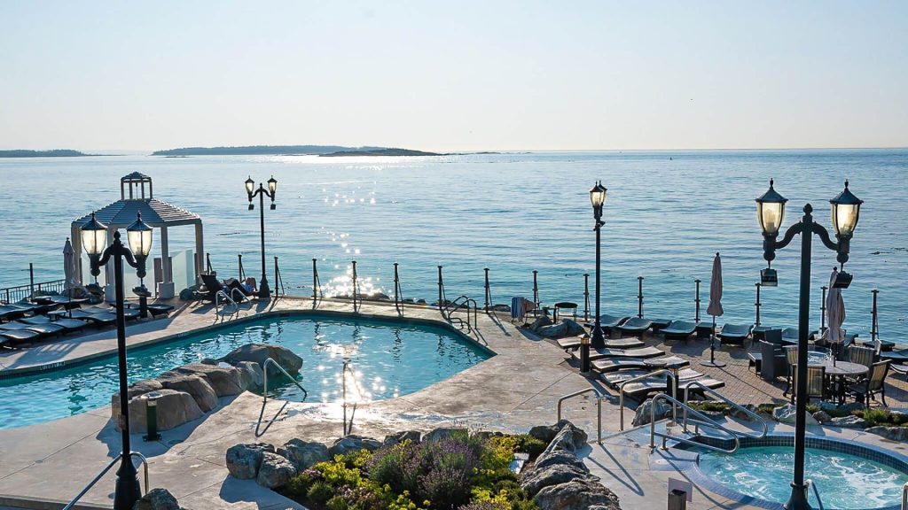luxury hotel amenities - A stunning image featuring the picturesque mineral pools at Oak Bay Beach Hotel in Victoria, British Columbia, with a mesmerizing view of the Pacific Ocean in the background.