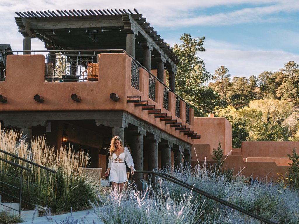 20 unforgettable stays - Bishop's Lodge viewed from outdoors with a woman standing in front