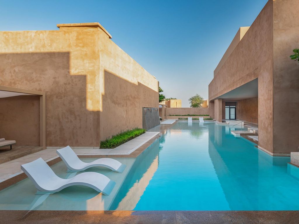 adults only hotels - Zulal Wellness Resort by Chiva-Som outdoor pool with white loungers, between two buildings