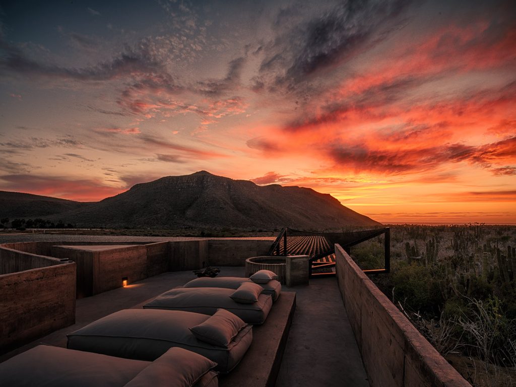 Paradero Todos Santos – row of loungers in front of a colorful sunset