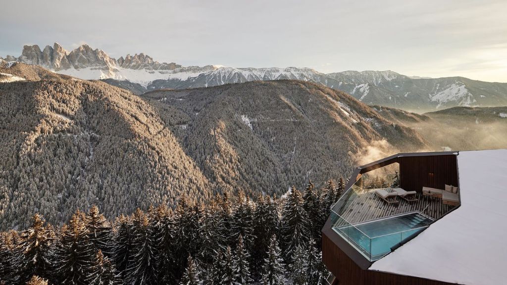 coolest ski resorts - FORESTIS suite with a pool overlooking a snowy mountain range