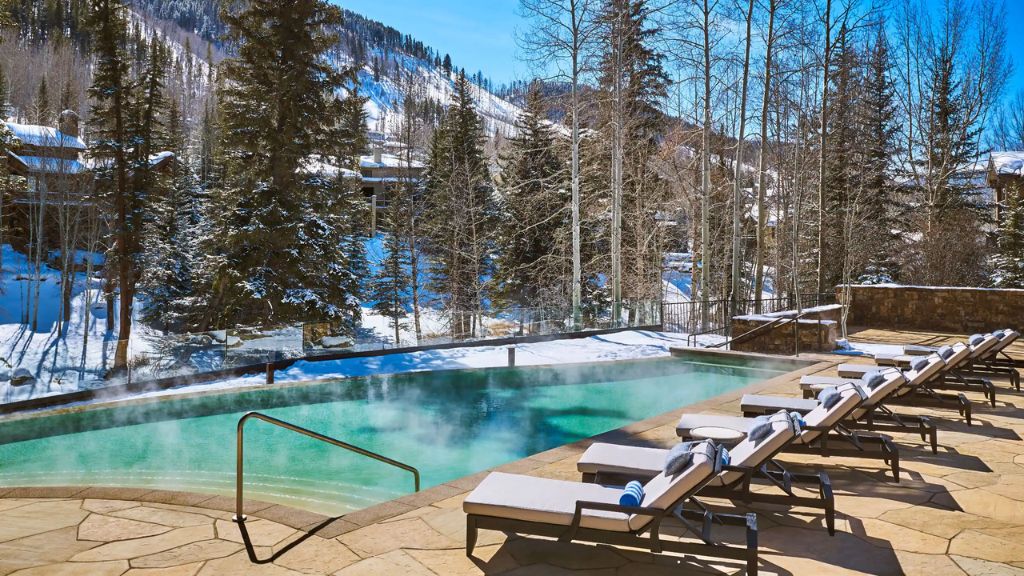 coolest ski resorts - a pool with hot water and lounge chairs
