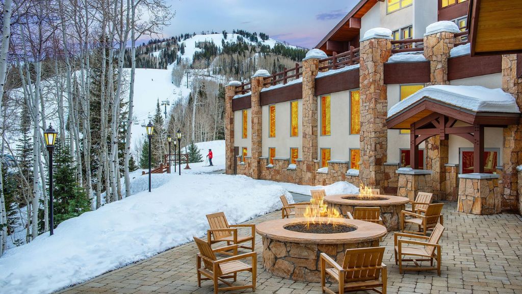 coolest ski resorts - a fire pit outside a Stein Eriksen Lodge, surrounded by snow