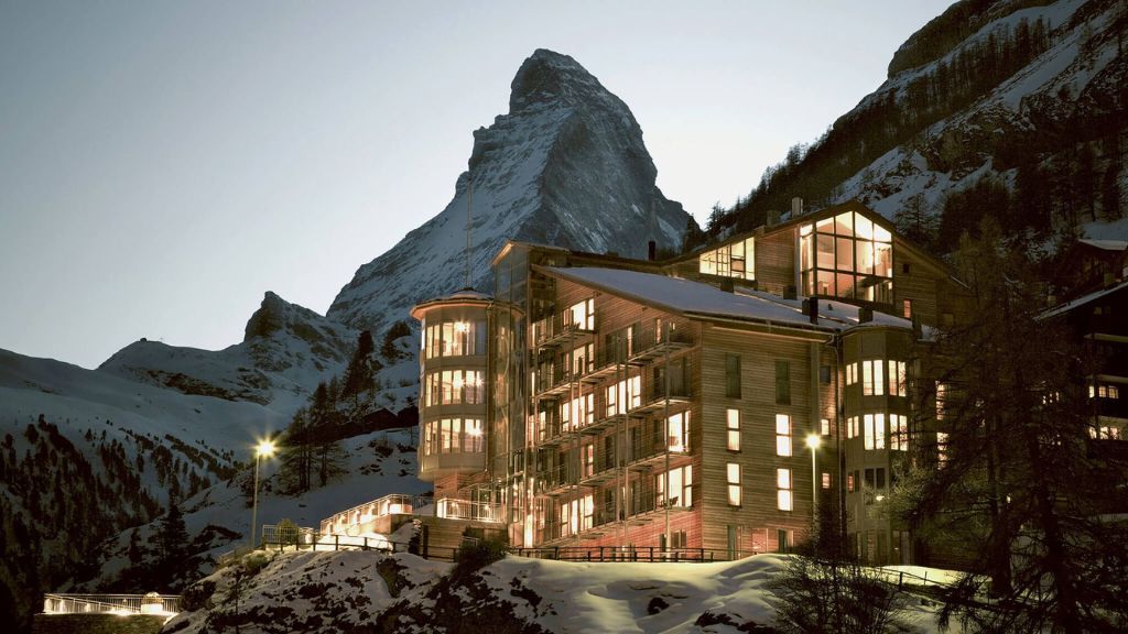 coolest ski resorts - The Omnia with lights on the side of it, in the evening
