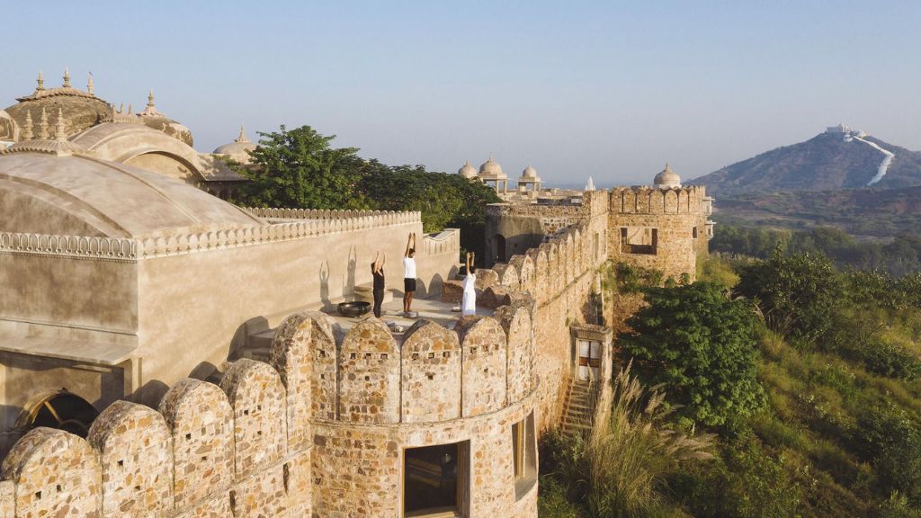 passion travel - Six Senses Fort Barwara - a group of people standing on a wall of a castle