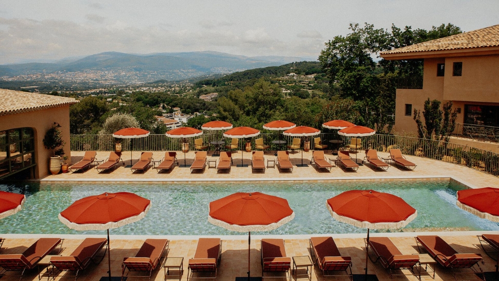 Best hotels in the South of France - Le Mas Candille - Mougins - pool lined with sunbeds and bright red umbrellas