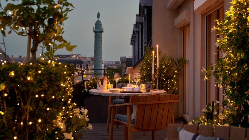 Proposal Hotels - Park Hyatt Paris-Vendôme - Classic Romantics - a table set up on a balcony with a tall tower in the background