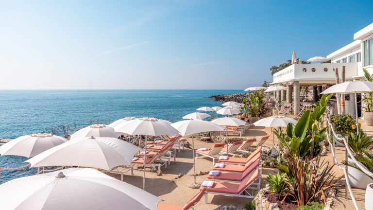 orange sunbeds and white umbrellas overlooking the Mediterranean Sea