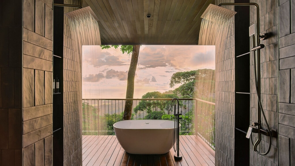 Small hotels | Rancho Pacifico, Uvita, Costa Rica | a bathtub on a deck with a shower overlooking the water