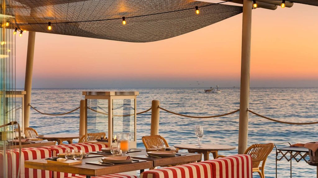 Sunset cocktails at Soleo at El Fuerte Marbella | Marbella, Spain | a table set up on a beach with a stunning Mediterranean sunset
