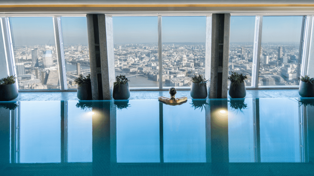 Skyscraper hotels - Shangri-La The Shard - London, United Kingdom - person in an indoor pool overlooking the Thames