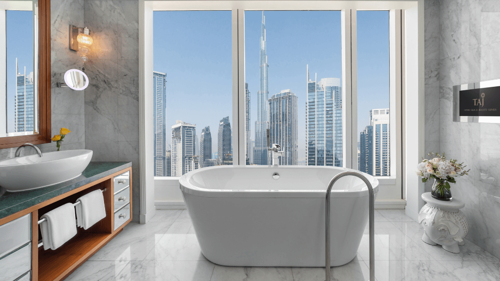 Skyscraper hotels - Taj Dubai - Dubai, UAE - bathtub in front of floor-to-ceiling windows with views of the Burj Khalifa