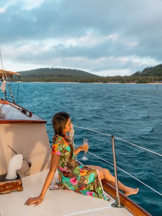 COMO Laucala Island Travel Diary by Jyo Shankar - woman on a boat at sunset