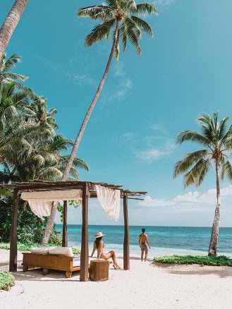 COMO Laucala Island Travel Diary by Jyo Shankar - couple lounging at beachfront cabana