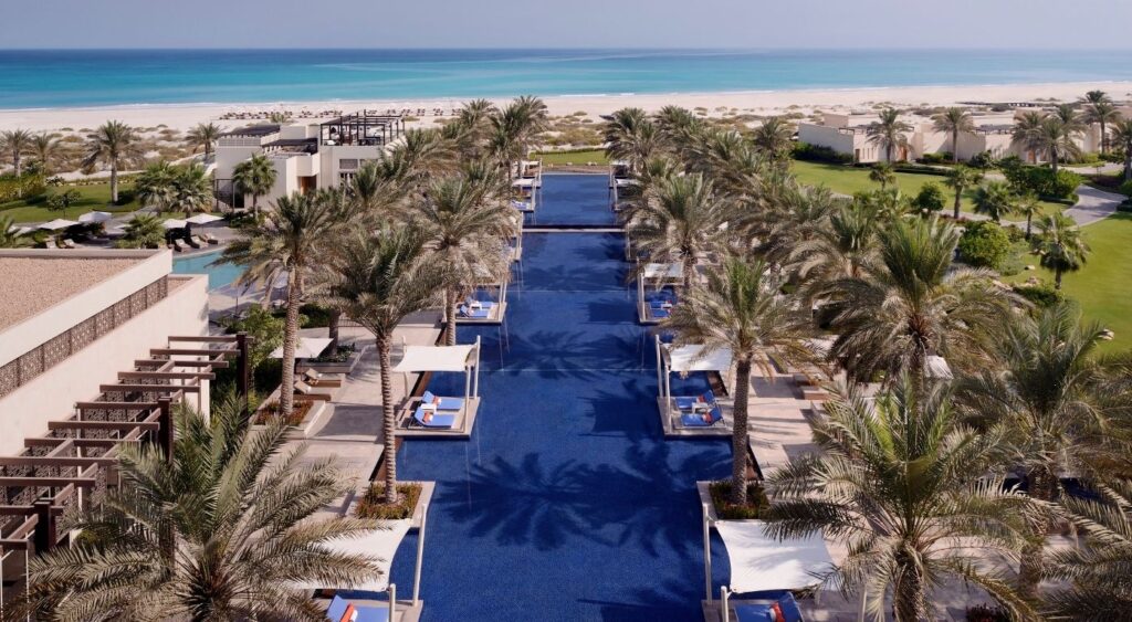 Best family hotels in Dubai - Park Hyatt Abu Dhabi Hotel and Villas -Abu Dhabi, United Arab Emirates - pool framed by palm trees leading to a private beach