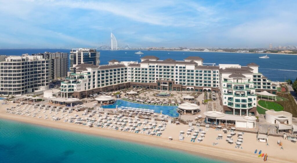 Taj Exotica Resort & Spa, The Palm, Dubai - Dubai, UAE - Aerial view of the hotel with water in front and behind