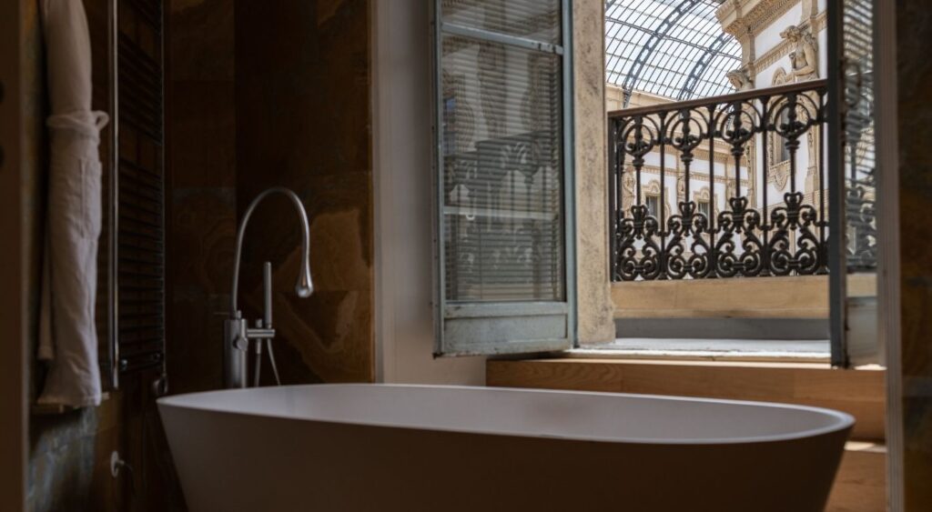 Luxury hotels in Milan - Galleria Vik Milano – Townhouse Galleria - Centro Storico - Bathtub in front of a window with views of the Galleria Vittorio Emanuele II shopping arcade