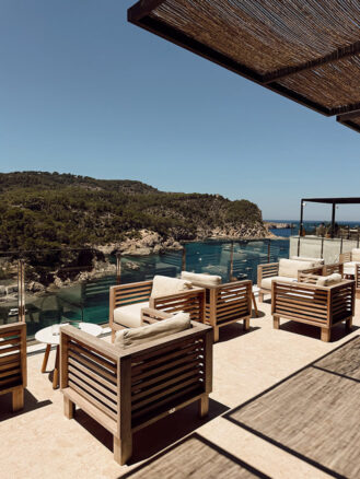 Portugal and Spain Travel Diary Itinerary by Christine Flynn | a patio with chairs and a view of the cala at Cala San Miguel Resort in Northern Ibiza, Spain