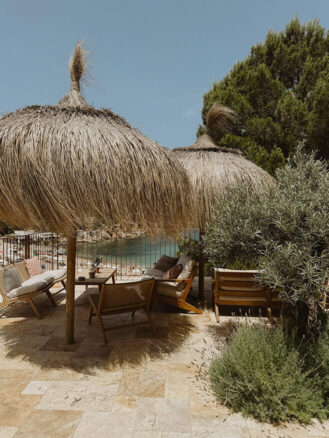 Portugal and Spain Travel Diary Itinerary by Christine Flynn | a patio with chairs and umbrellas at Cala San Miguel Resort in Northern Ibiza, Spain