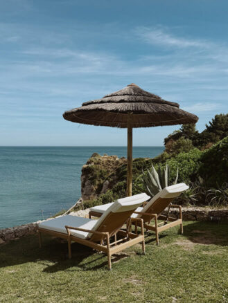 Portugal and Spain Travel Diary Itinerary by Christine Flynn | Lounge chairs with an umbrella and sea view at Vila Vita Parc in Porches, Algarve, Portugal