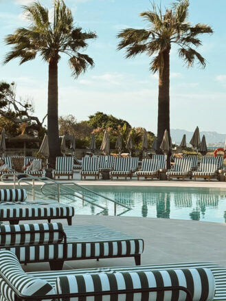 Portugal and Spain Travel Diary Itinerary by Christine Flynn | a pool with chairs and umbrellas at Sarena de Muro Resort Mallorca, Spain