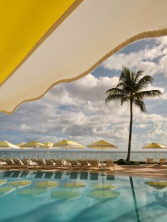 The Breakers Palm Beach | a pool scene with yellow umbrellas