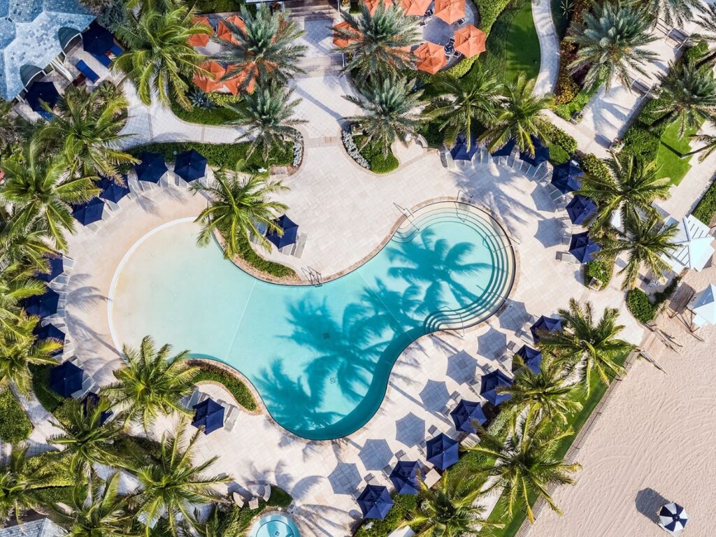 The Breakers Palm Beach Hotel Spotlight | A beachside pool surrounded by palm trees