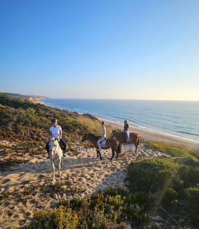 Day trip - People horseback riding along Praia do Meco, Portugal