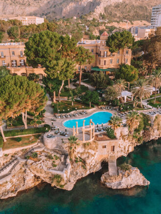 Where to stay in Sicily travel diary - aerial view of Villa Igiea, showcasing the hotel and the pool along the cliffs above the ocean